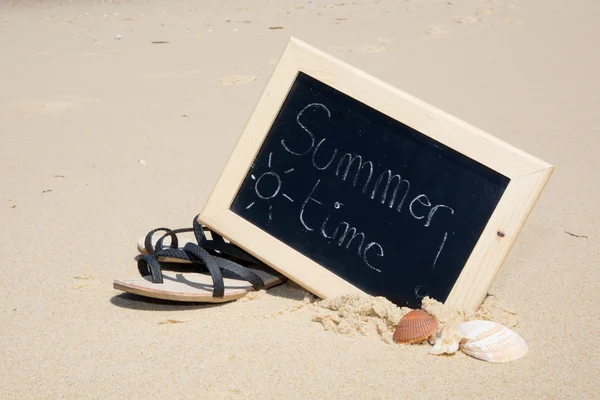 Summer time written on a chalkboard at the beach holidays — Stock Photo, Image