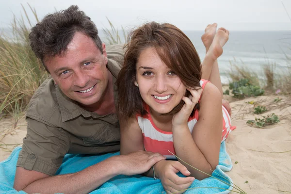 Glückliches Paar, das sich am Strand umarmt und gemeinsam lacht — Stockfoto