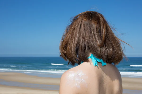 Mulher está tendo banhos de sol com sol bronzeado loção sol desenho — Fotografia de Stock