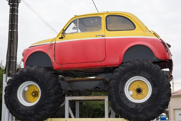 Taşınan eski komik sarı ve kırmızı küçük araba — Stok fotoğraf