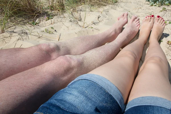 Pernas na praia de um casal apaixonado — Fotografia de Stock