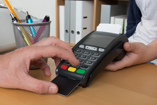 Рука штовхає кредитну картку В машину кредитних карток — стокове фото