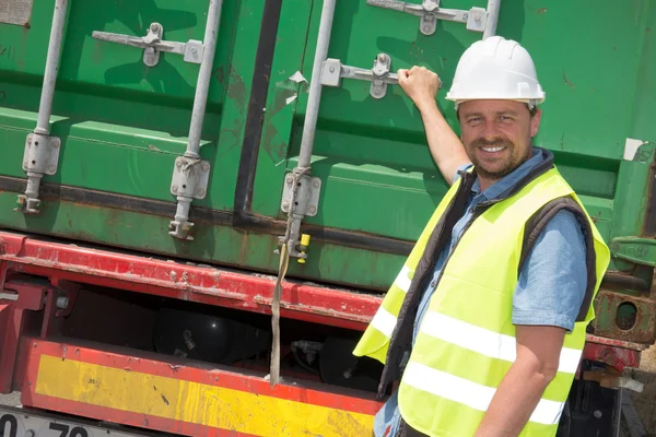 Road bouwvakker permanent naast de vrachtwagen op locatie site — Stockfoto