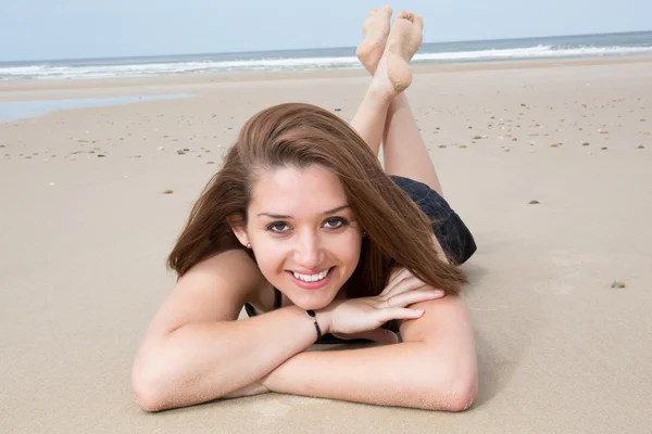 Giovane donna allegra e bella sdraiata sulla spiaggia — Foto Stock