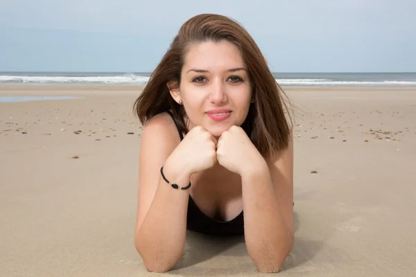 Glad och vacker ung kvinna ligga på stranden — Stockfoto