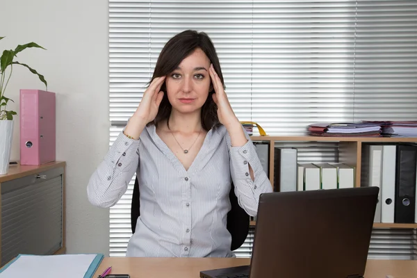 Vyčerpaná podnikatelka v její kanceláři s hlavou v ruce — Stock fotografie