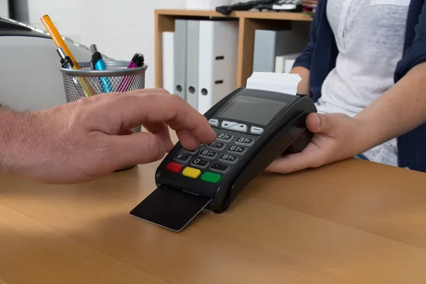 Mão com cartão de crédito em uma máquina de cartão de crédito — Fotografia de Stock