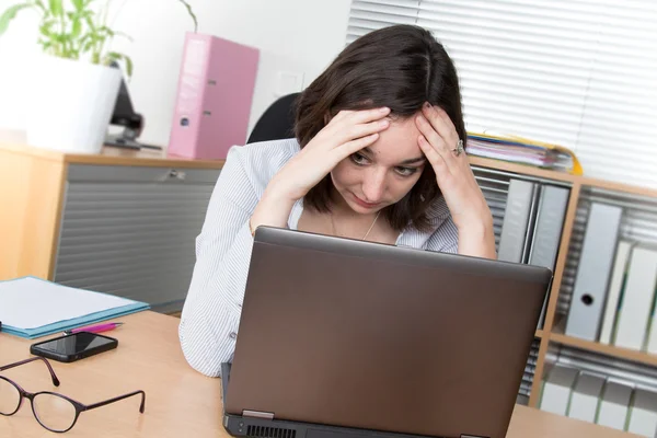 Mujer joven sobrecargada de trabajo y frustrada frente a la computadora —  Fotos de Stock