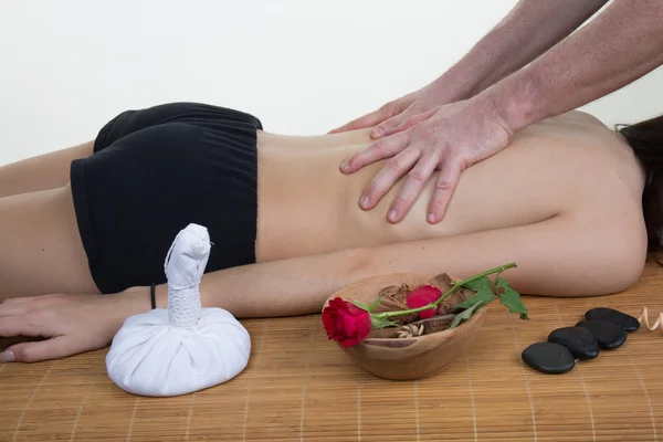 Jovem deitada em uma mesa de massagem e está sendo massageada — Fotografia de Stock