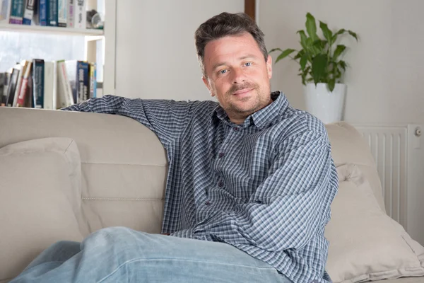 Hombre sin afeitar, en casa sentado mirando a la cámara — Foto de Stock