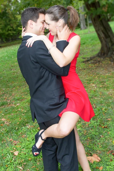 Hermosa pareja enamorada tiernamente abraza en rojo y negro —  Fotos de Stock
