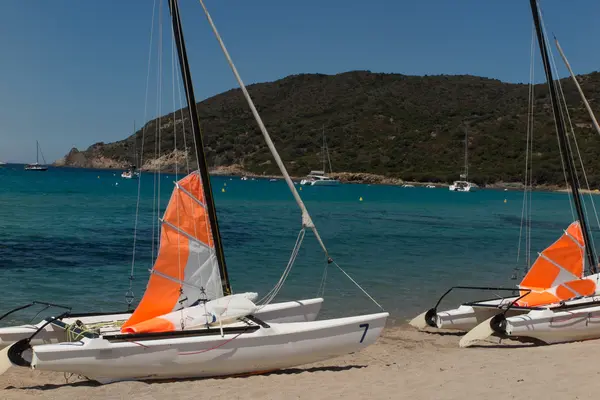 Katamarane mit ihren bunten Segeln breiten sich am Strand von Korsika aus — Stockfoto