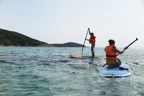 Szép és boldog fiatal lány tanulás lapát-surf — Stock Fotó