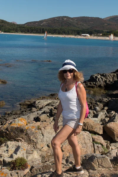 Woman tourist standing on cliff and looking at the camera — Stock Photo, Image