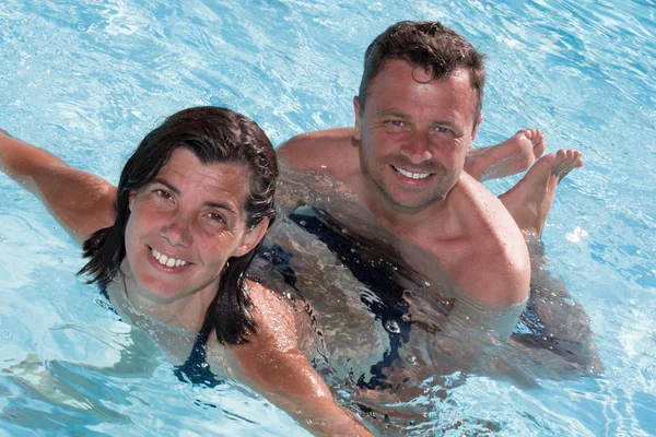Çift, erkek ve kadın bir havuzda eğleniyor — Stok fotoğraf