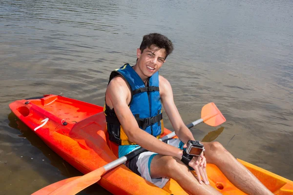 Jovem feliz remando no lago em caiaque e sorrindo — Fotografia de Stock