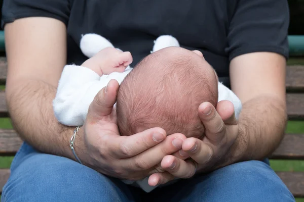 Father holding head of his newborn son in hands. — Stock Photo, Image