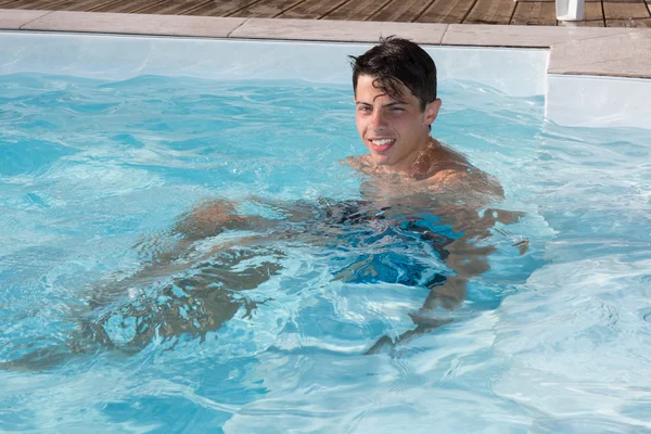 Jonge man in het zwembad in de zomer — Stockfoto