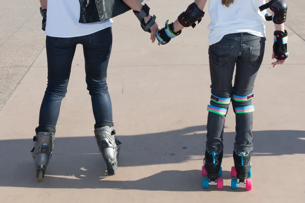 Dois adolescentes meninas amigos de mãos dadas patinação rolo juntos — Fotografia de Stock