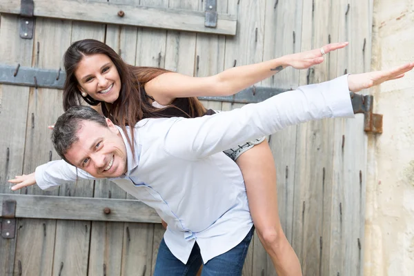 Verliebtes Paar - kaukasischer Mann mit seiner Frau huckepack auf dem Arm — Stockfoto