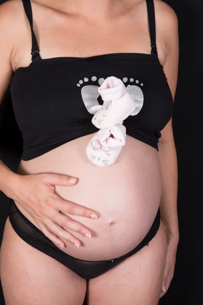 Schwangere Mit Kleinen Rosafarbenen Socken Vor Dem Bauch Großaufnahme — Stockfoto