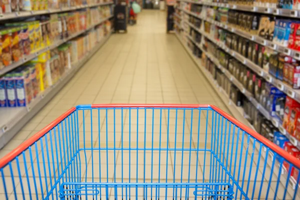 Супермаркет интерьер, пустая красная корзина . — стоковое фото