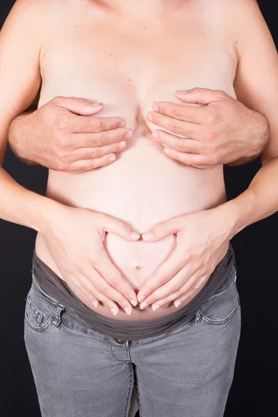 Mulher grávida fazendo forma de coração com as mãos . — Fotografia de Stock