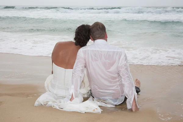 Rear view of loving couple relaxing on beach, kissing outdoors, — Stock Photo, Image