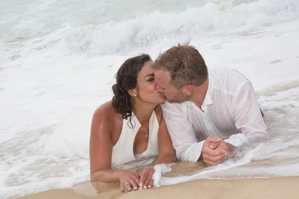 Noivo amoroso beijando a boca da noiva na praia — Fotografia de Stock