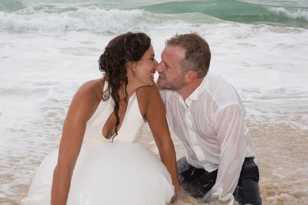 Romantiska nyligen gift par. Unga brudgummen kyssa hans brud i havet — Stockfoto