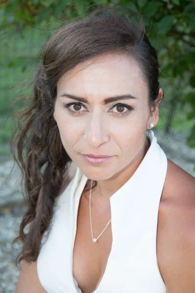 Frau mit langen glatten dunklen Haaren trägt klassisches weißes Top — Stockfoto