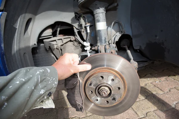 Mechanic man is changing a wheel of a car — Stock Photo, Image