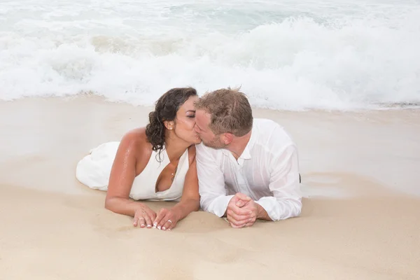 Milující ženicha líbat nevěsty ústa na pláži — Stock fotografie
