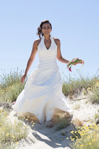 Hezká nevěsta chůzi podél pobřeží moře na sobě krásné svatební šaty — Stock fotografie
