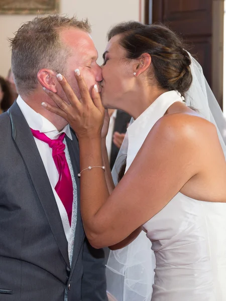 Поцелуй между красивой молодой свадебной парой влюбленных — стоковое фото