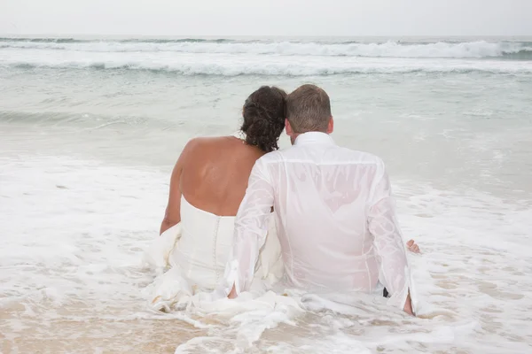 Rear view of loving couple relaxing on beach, kissing outdoors, — Stock Photo, Image