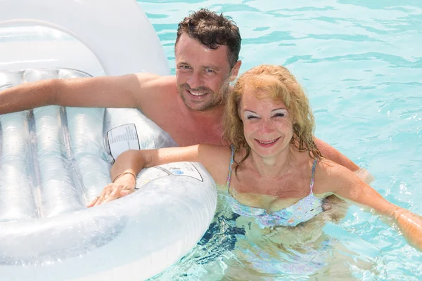 Alegre pareja de mediana edad de vacaciones en la piscina —  Fotos de Stock