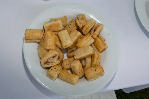 Rolos de salsicha em um prato, isolado em branco, comida tradicional do Natal britânico . — Fotografia de Stock