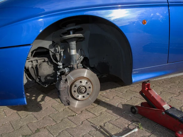 Man changing a wheel of modern car in a workshop — Stock Photo, Image