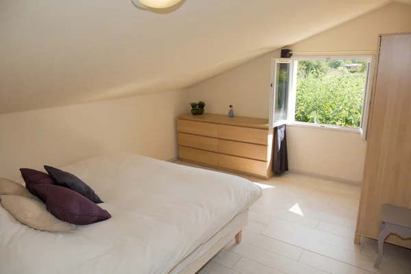 Светлая спальня на чердаке с большой кроватью — стоковое фото