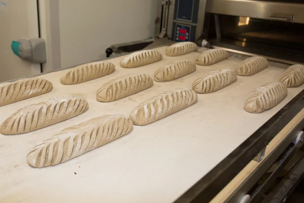 Baker tomando pan recién horneado del horno. Proceso de fabricación —  Fotos de Stock