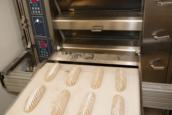 Baker tomando pan recién horneado del horno. Proceso de fabricación —  Fotos de Stock