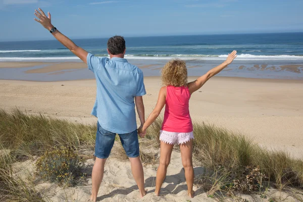 海滩上欢呼的幸福免费夫妻外出旅游度假。后视图 — 图库照片