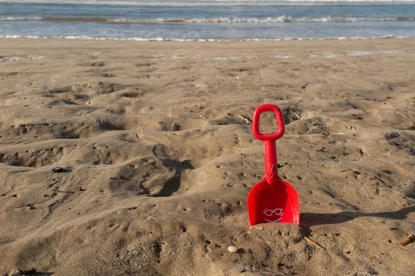 Juguete de playa rojo en la arena sonriendo en la playa tropical — Foto de Stock