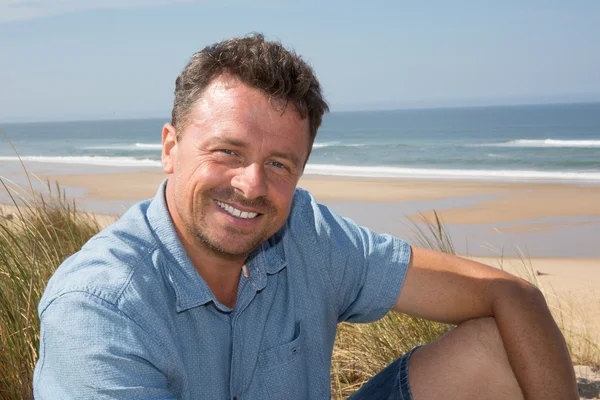 Plajda yaz seyahat tatil keyfini kuma oturan adam — Stok fotoğraf