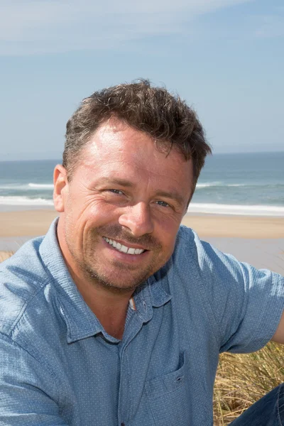Przystojny mężczyzna na plaży patrząc na kamery — Zdjęcie stockowe