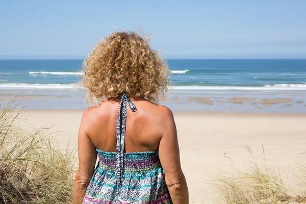 Felice bionda in piedi nel mare in posa in una giornata di sole — Foto Stock