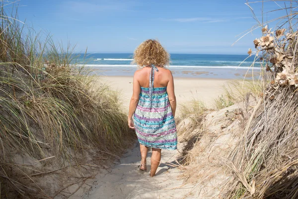 Felice bionda in piedi nel mare in posa in una giornata di sole — Foto Stock