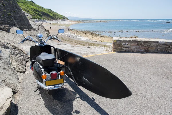 Винтажный скутер с доской для серфинга на прекрасном пляже — стоковое фото