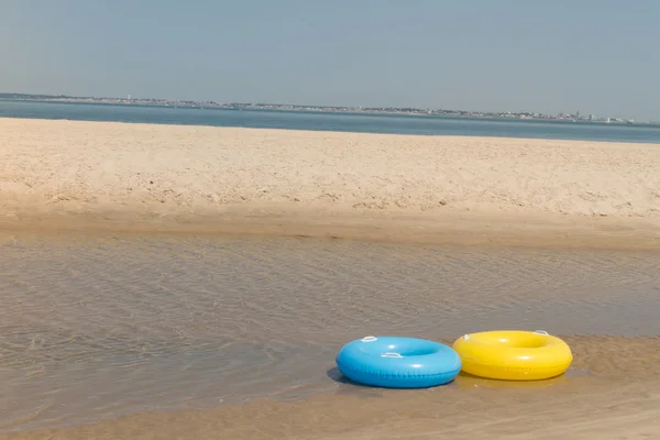 Dvě hračky zachránce ležet na pláži — Stock fotografie